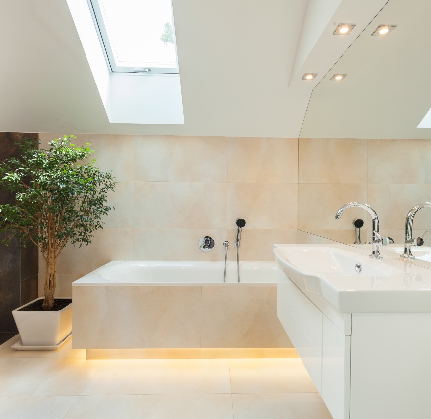 Modern eingerichtetes Badezimmer. Eine warmweiß unterleuchtete Badewanne erweckt den Eindruck zu schweben. 